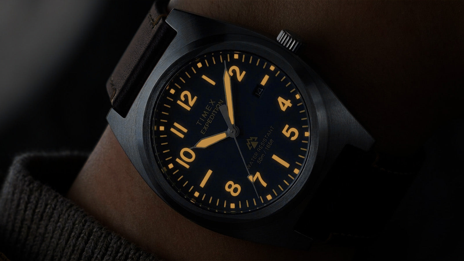 Timex Expedition Capstone watch with glowing lume markers and hands on wrist in low light