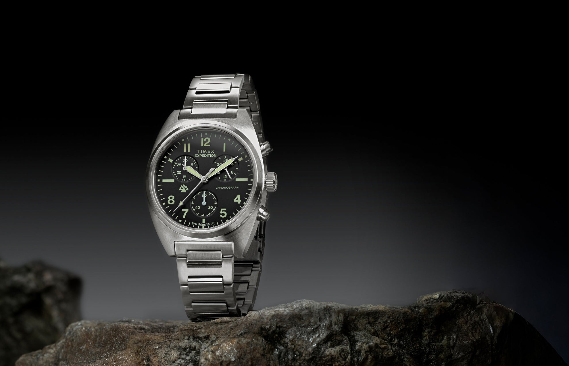Timex Expedition Capstone Chronograph with stainless steel bracelet displayed on rocks outdoors