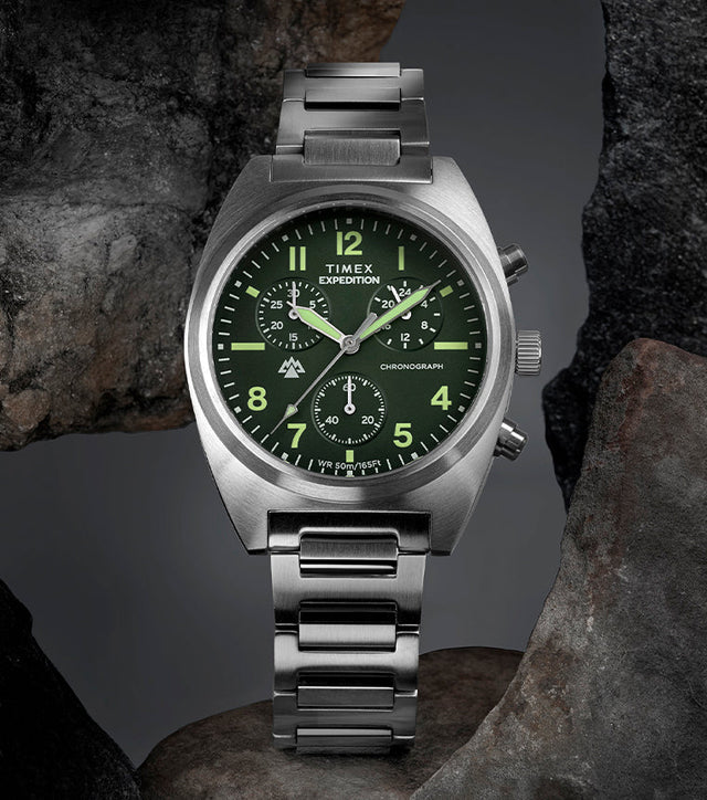 Timex Expedition Capstone Chronograph with green dial and stainless steel bracelet displayed on rocks