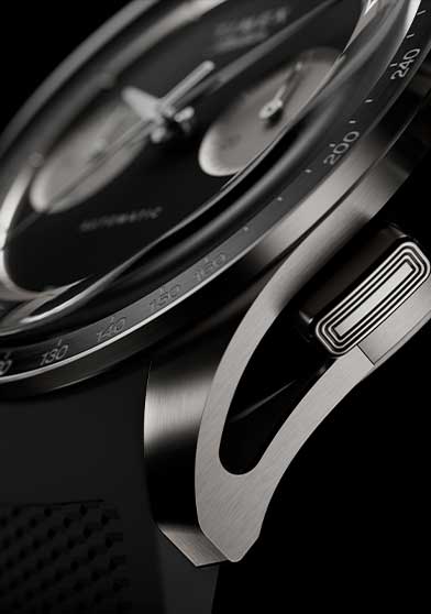 Side detail of Timex Atelier Chronograph Automatic Ti M1a titanium case with tachymeter bezel, crown, and black rubber strap