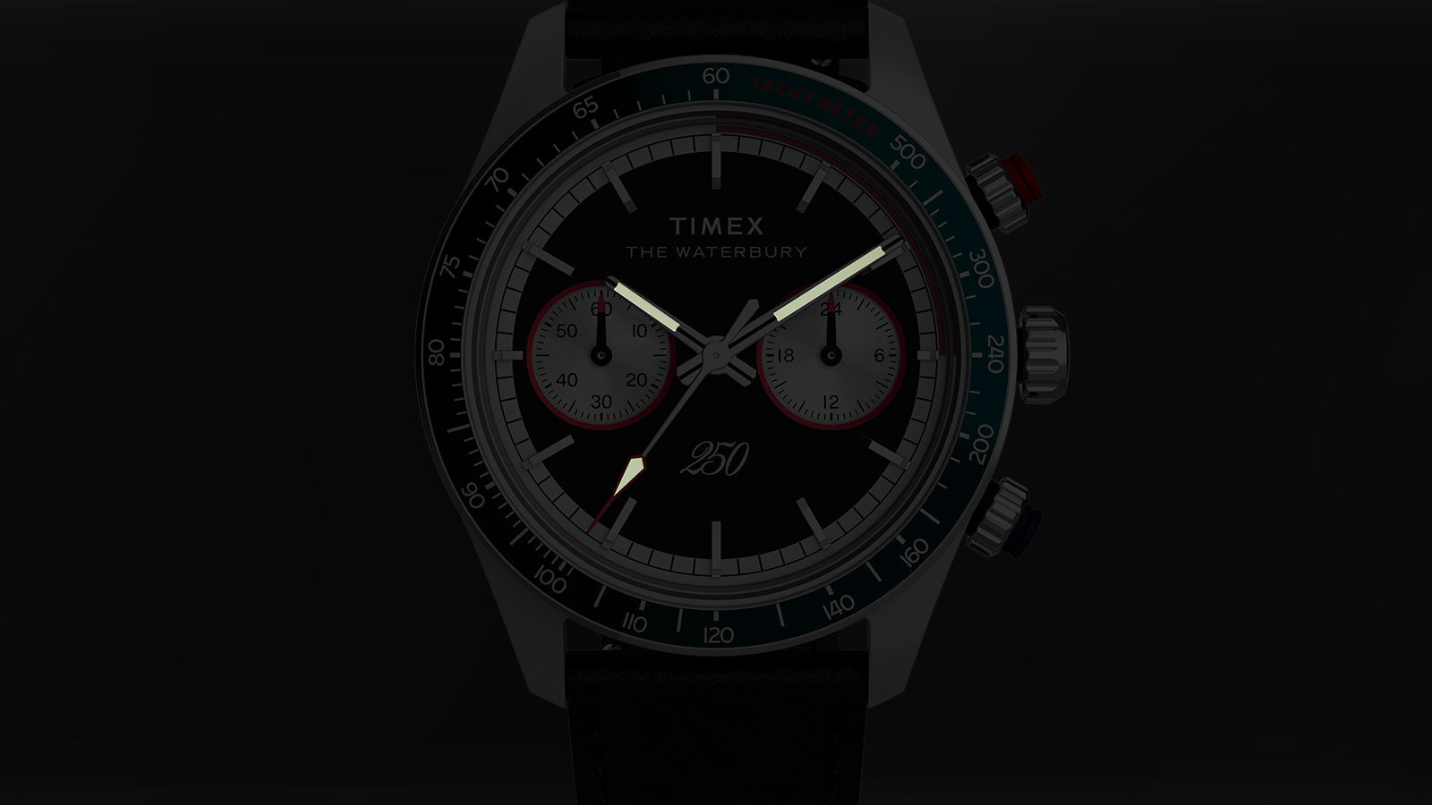 Detailed view of the Waterbury Heritage America 250 Chronograph with illuminated hands and markers against a dark background.