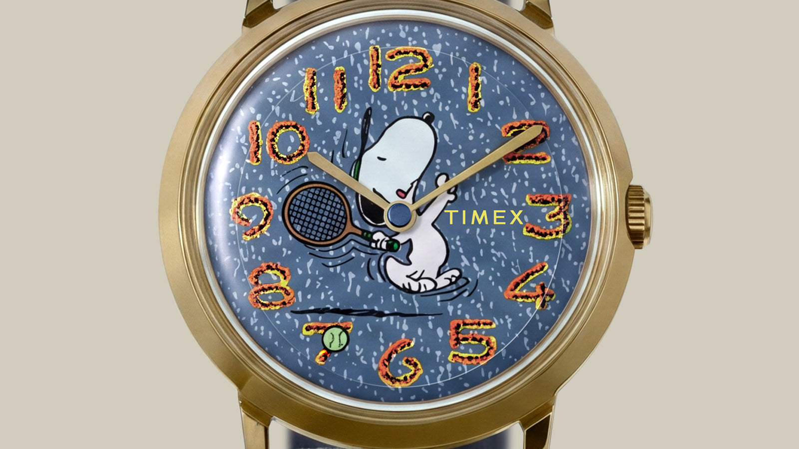 Close-up of the Peanuts® x Timex Marlin® 1965 Reissue Inspired Snoopy Tennis dial featuring Snoopy holding a tennis racket and colorful embroidered-style numerals.