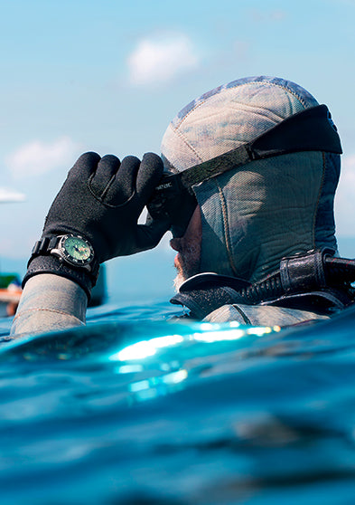 Professional diver wearing the Timex Deepwater Meridian 300 Titanium HEV Automatic while observing the ocean from the water's surface.