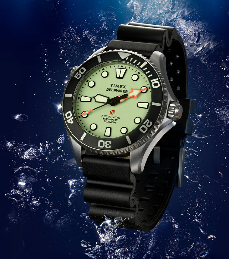 Timex Deepwater Meridian 300 Titanium HEV Automatic dive watch with a luminous dial and black rubber strap against an underwater background.