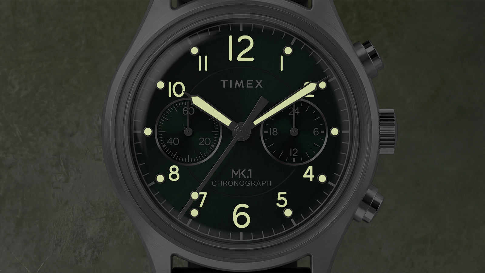 Close-up of the Timex MK1® Chronograph highlighting luminous hands, glowing hour markers, and chronograph subdials in low light.