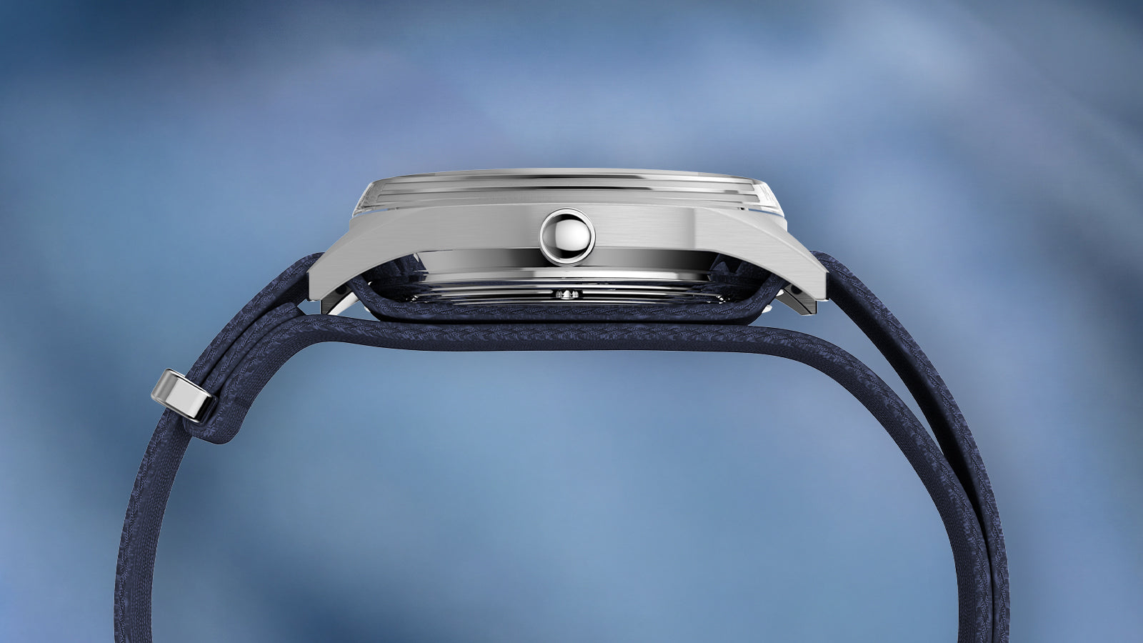 Side profile of the Peanuts® x Timex Marlin® Jet Automatic Easy Rider watch highlighting its slim silver-tone stainless steel case, domed crystal, and textured blue woven strap.