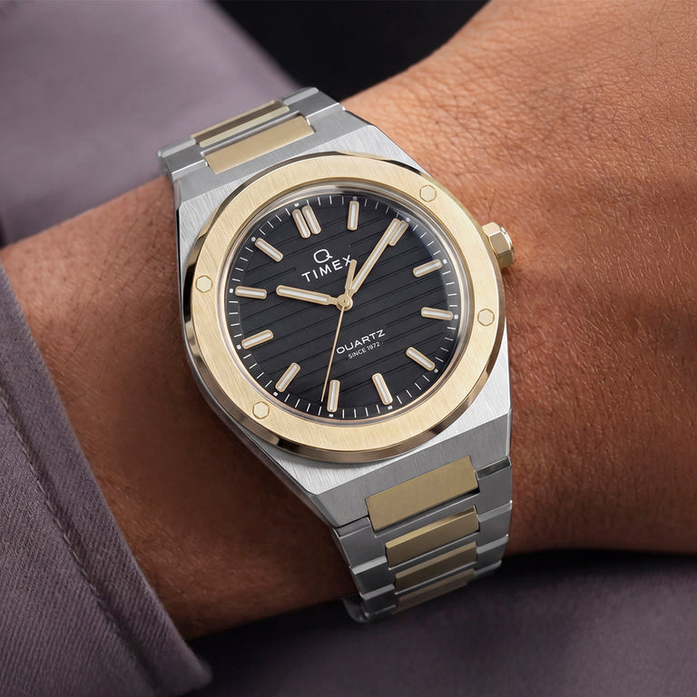 Timex Q Marbella two-tone stainless steel watch with a black dial worn on the wrist.