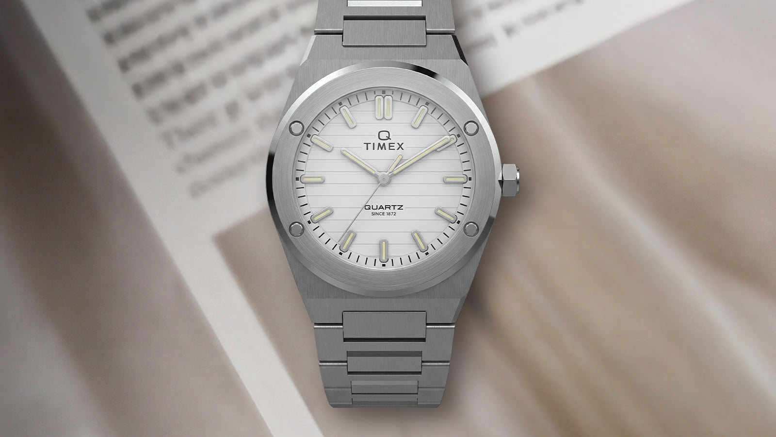 Front view of the Q Timex Marbella stainless steel watch featuring a silver dial and integrated stainless steel bracelet.