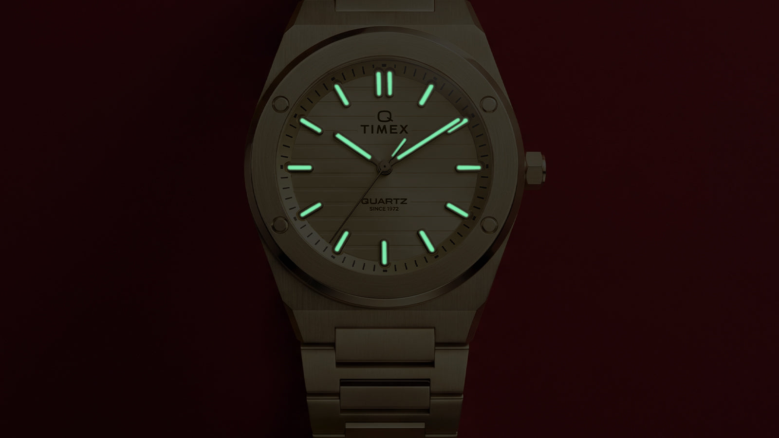 Front view of the Q Timex Marbella gold-tone watch showcasing illuminated Indiglo® hands and hour markers.