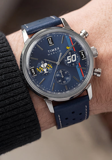 Peanuts® x Timex Marlin® Chronograph on the wrist featuring a blue dial, silver-tone stainless steel case, and perforated blue leather strap.