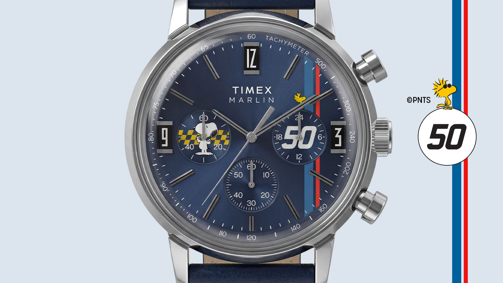 Close-up of the Peanuts® x Timex Marlin® Chronograph blue dial with Snoopy chronograph subdial, Woodstock accent, racing stripes, and tachymeter scale.