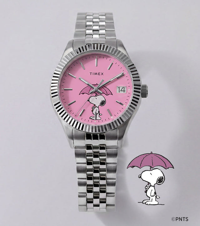Peanuts® x Timex Legacy Snoopy Umbrella watch with a pink dial, stainless steel bracelet, and Snoopy holding a pink umbrella beside the watch.