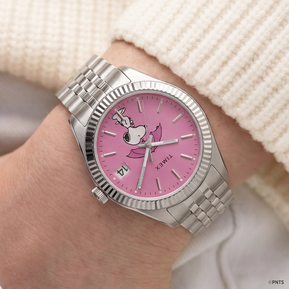 Peanuts® x Timex Legacy Snoopy Umbrella watch worn on the wrist, showcasing the pink dial with Snoopy holding a pink umbrella and a stainless steel bracelet.