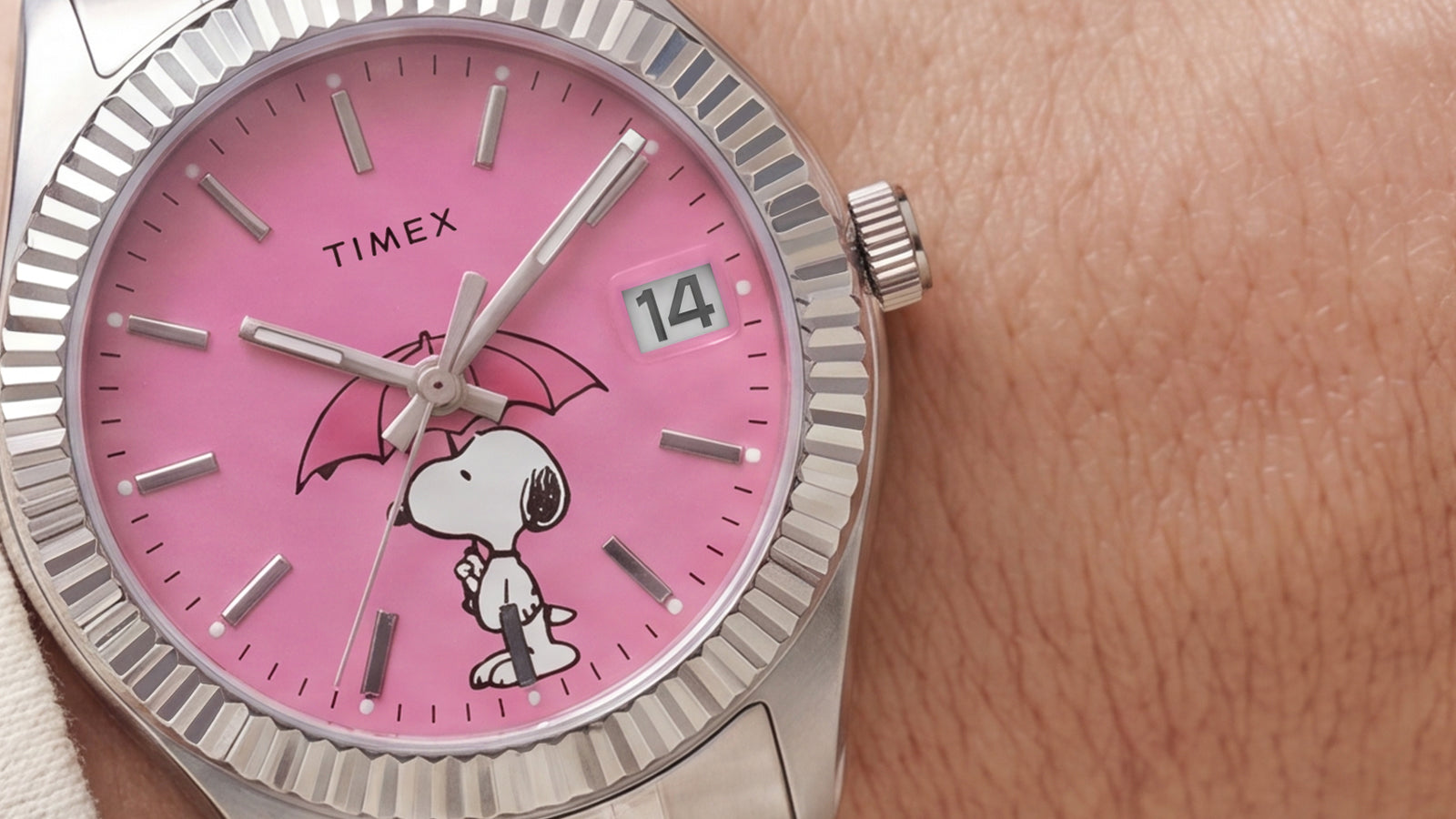 Close-up of the Peanuts® x Timex Legacy Snoopy Umbrella watch featuring a pink dial, Snoopy holding a pink umbrella, silver-tone markers, and a date window.