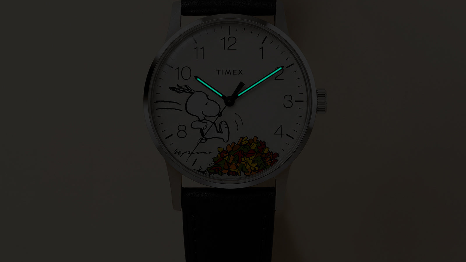 Close-up of the Peanuts® x Timex Waterbury Classic watch with INDIGLO® light-up hands and Snoopy autumn leaves artwork.