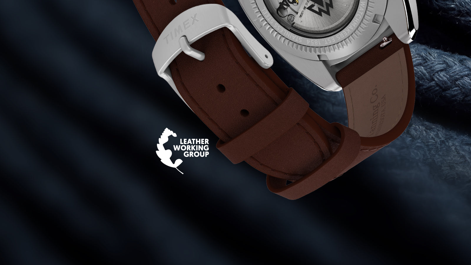 Brown leather strap and stainless-steel buckle of the Timex Expedition Pioneer Automatic, with the exhibition caseback partially visible.