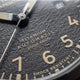 Close-up of the Expedition® Field Post Automatic textured black dial showing automatic movement, 200m water resistance, and shock resistance.