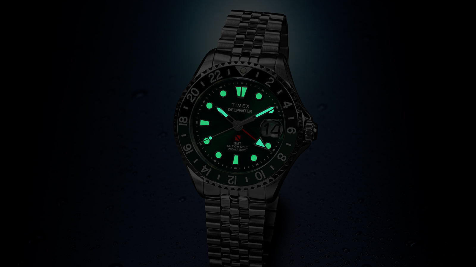 Timex Deepwater Meridian 200 Automatic GMT in low light with luminous hands and hour markers glowing brightly for enhanced nighttime readability.