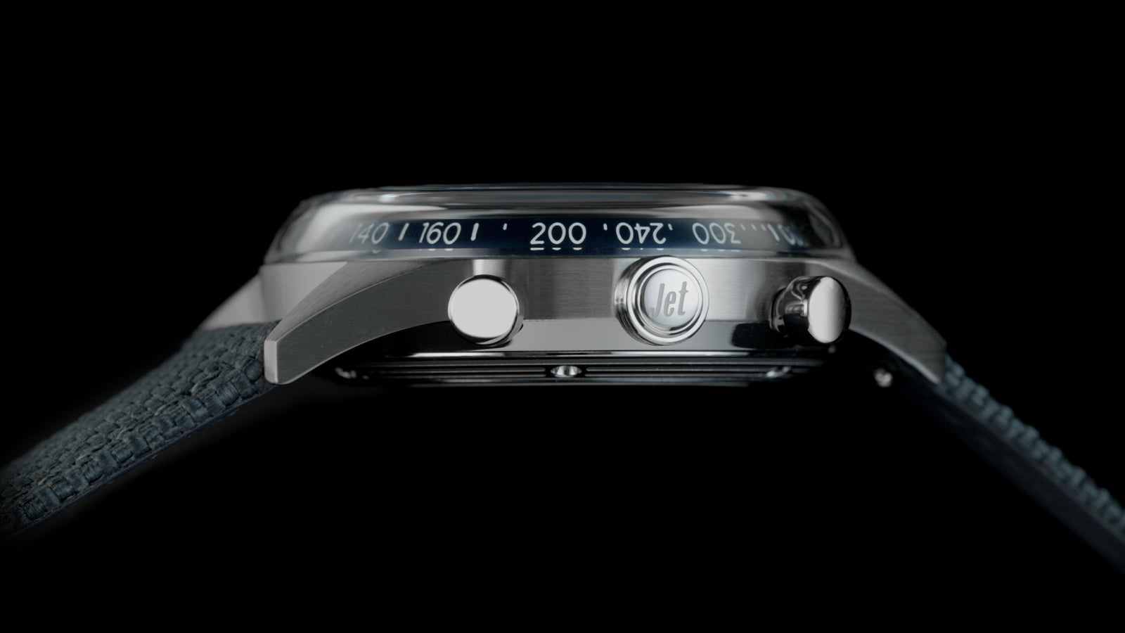 Side view of the Timex Marlin® Jet Chronograph highlighting its domed crystal, blue tachymeter scale, crown, pushers, and blue fabric strap.