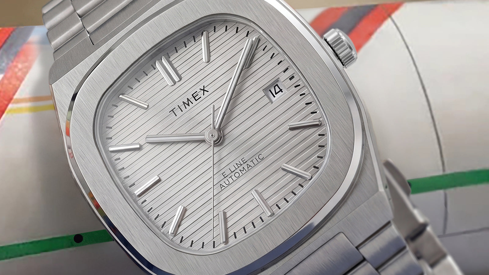 Close-up of the Timex® Automatic E Line 38mm featuring a silver textured dial, date window, brushed stainless steel case, and integrated stainless steel bracelet.