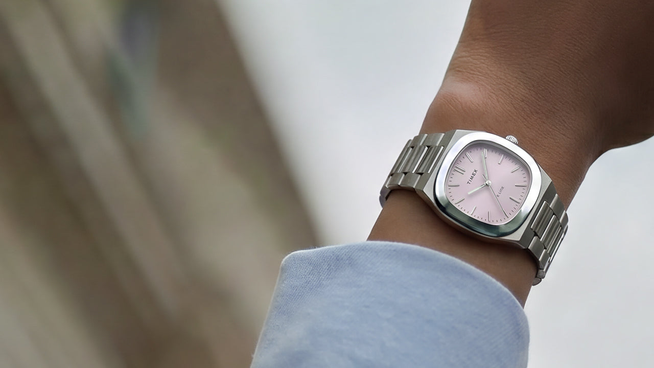 Close-up of the Timex® Quartz E Line 30mm stainless steel watch with a pink sunray dial worn on the wrist.