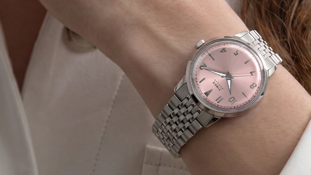Close-up of the Timex Marlin Quartz with a pink sunray dial and stainless steel bracelet worn on the wrist.