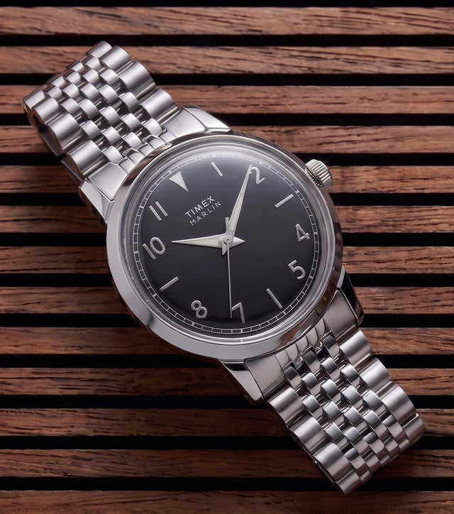 Timex Marlin Quartz watch with a black sunray dial and stainless steel bracelet displayed on a slatted wood surface.