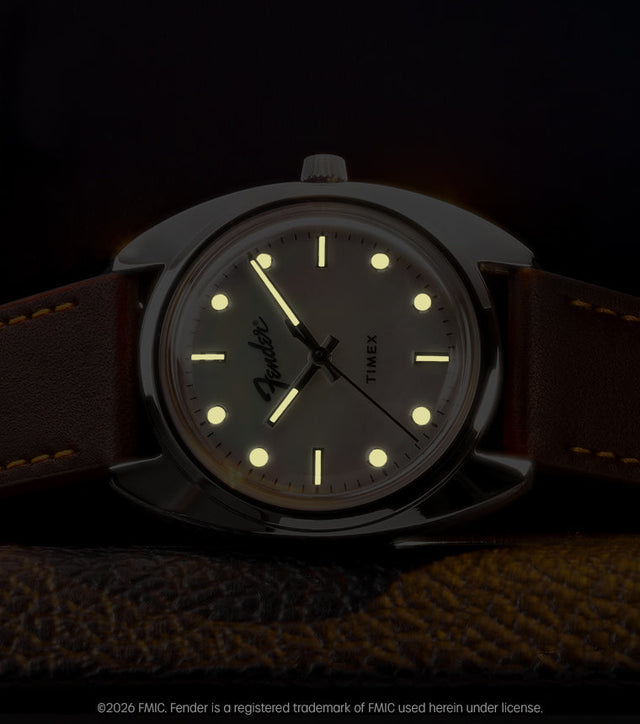Fender x Timex watch displayed in low light with glowing hands and hour markers.