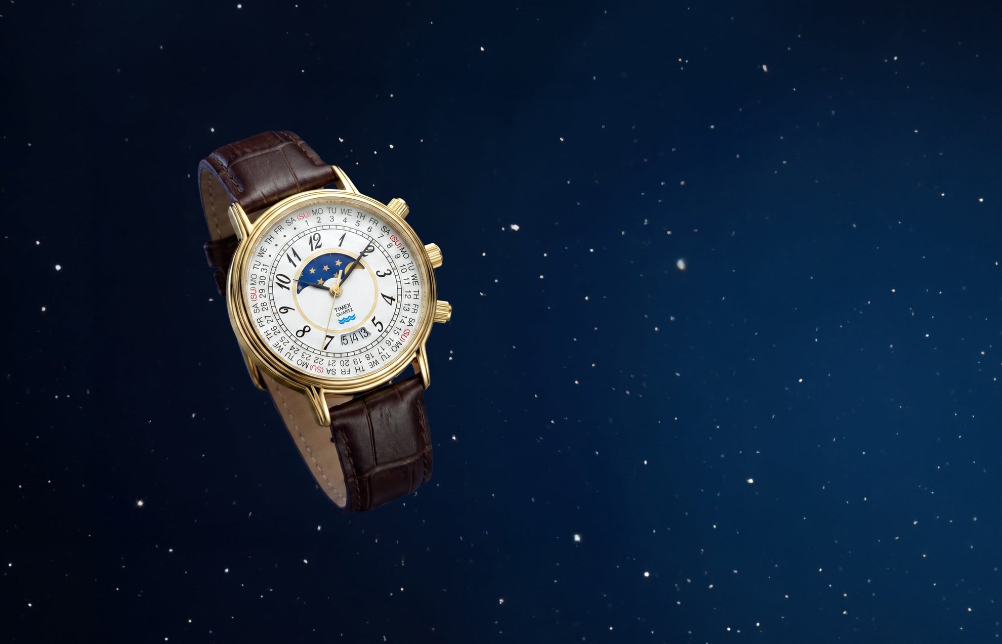 Timex 1990 Moon Phase and Calendar Dial Reissue with a gold-tone case, white calendar dial, moon phase display, and brown leather strap against a starry blue background.