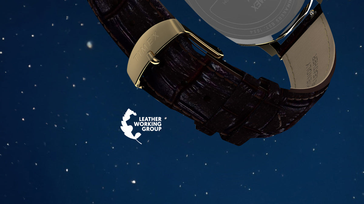 Close-up of the watch’s brown croc-embossed leather strap, gold-tone Timex buckle, and caseback against a starry blue background.