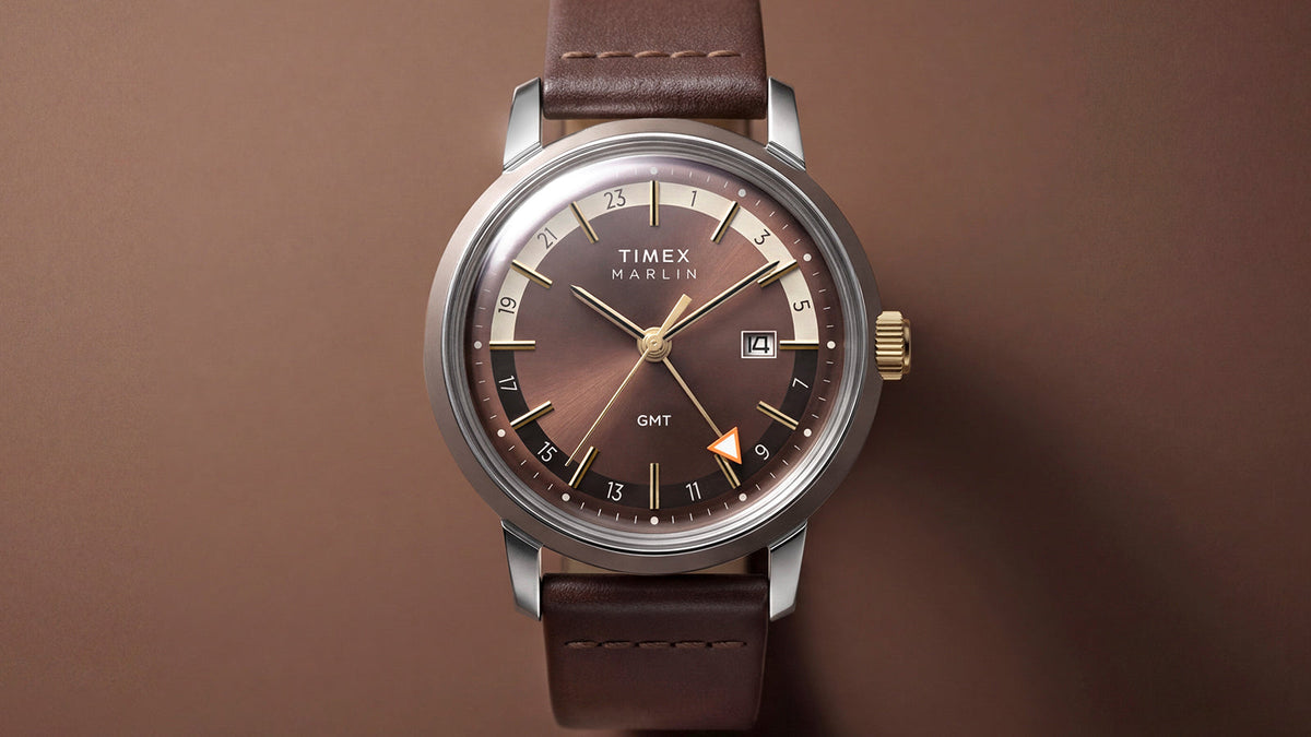 Front view of the Marlin® Quartz GMT with a brown dial, gold-tone accents, orange GMT hand, and leather strap.