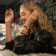 Woman wearing the Cavatina® Mini watch while listening to headphones and browsing records.