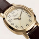 Close-up of the Cavatina® Mini, highlighting its champagne dial, black Arabic numerals, and polished gold-tone case.