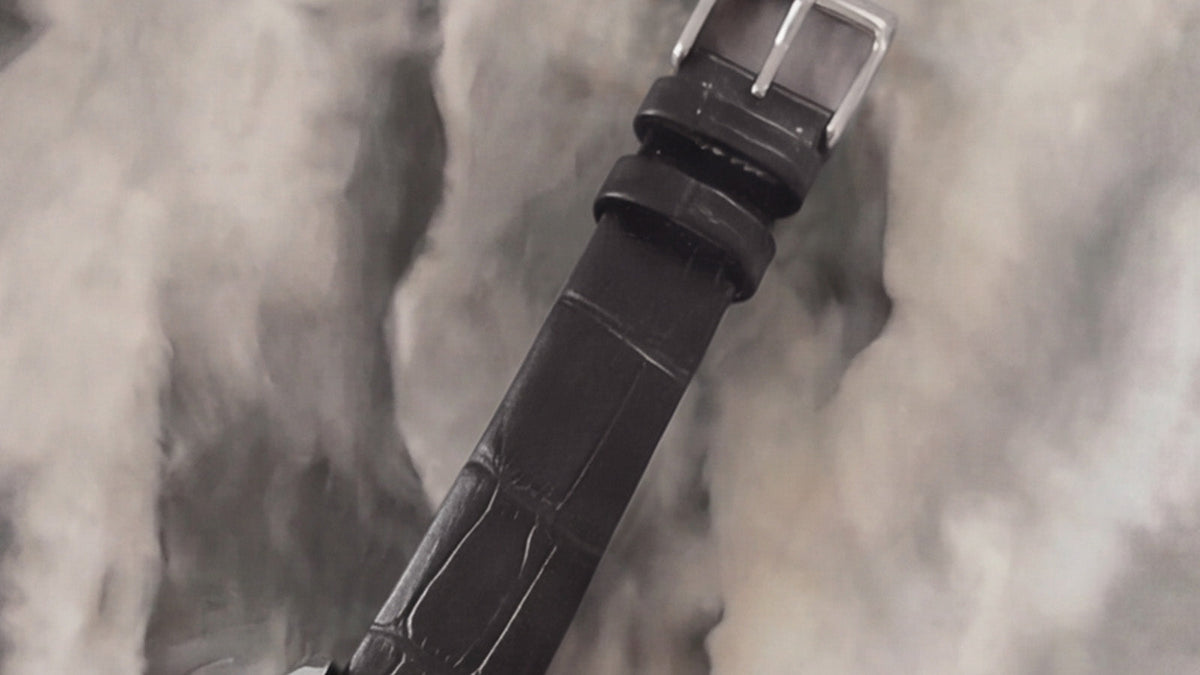 Close-up of the Addison watch’s black croc-embossed leather strap and silver-tone buckle.