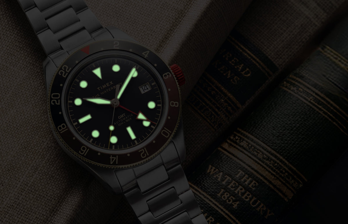 Waterbury Heritage Automatic GMT watch in low light, highlighting its luminous hands and hour markers.