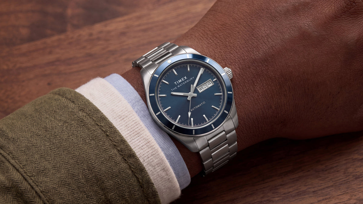 Waterbury Heritage Automatic with a blue dial and stainless-steel bracelet worn on a wrist.