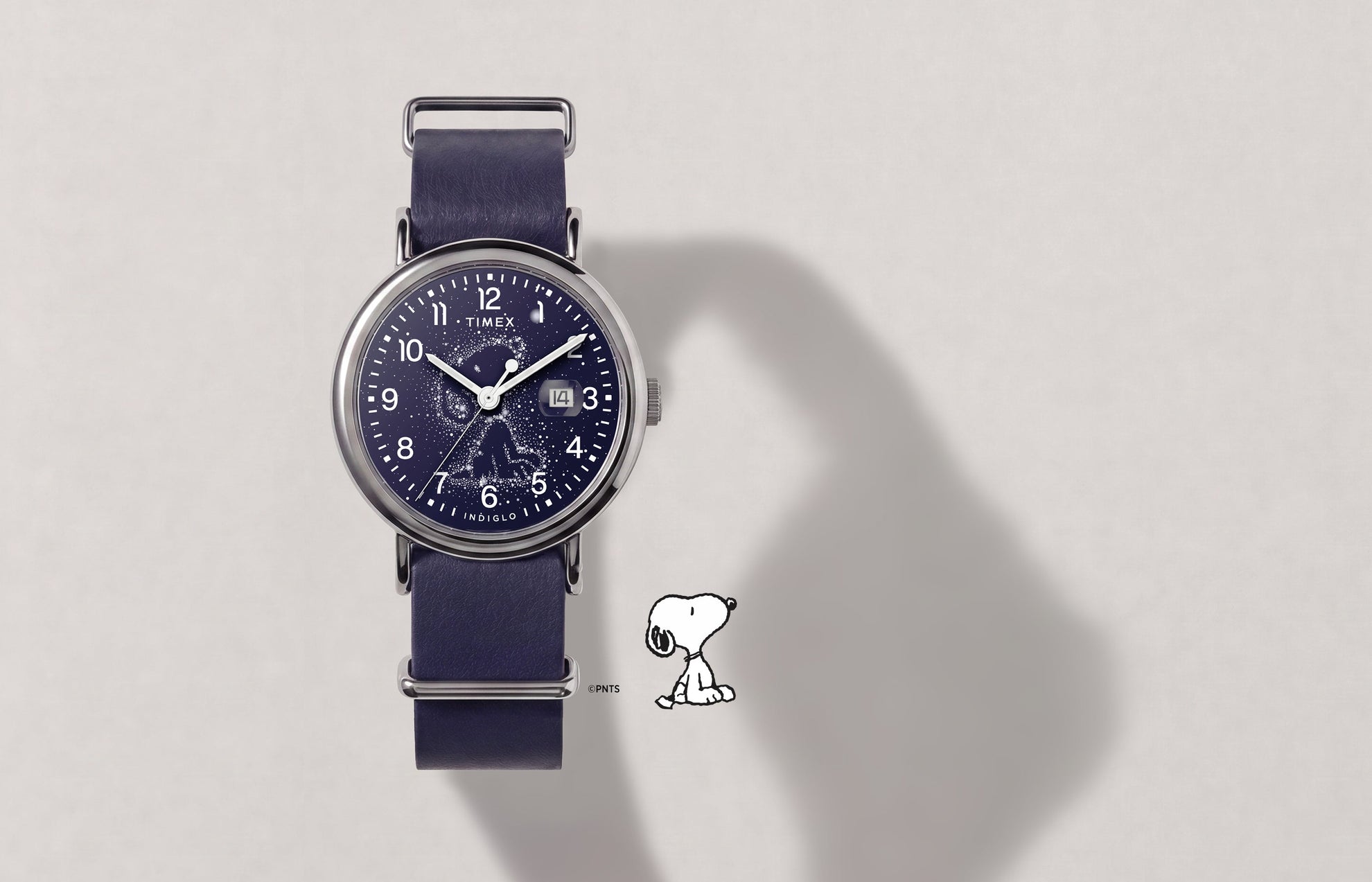 Peanuts® x Timex Weekender Astronomy watch with a navy strap, silver-tone case, Snoopy constellation dial, and date window.