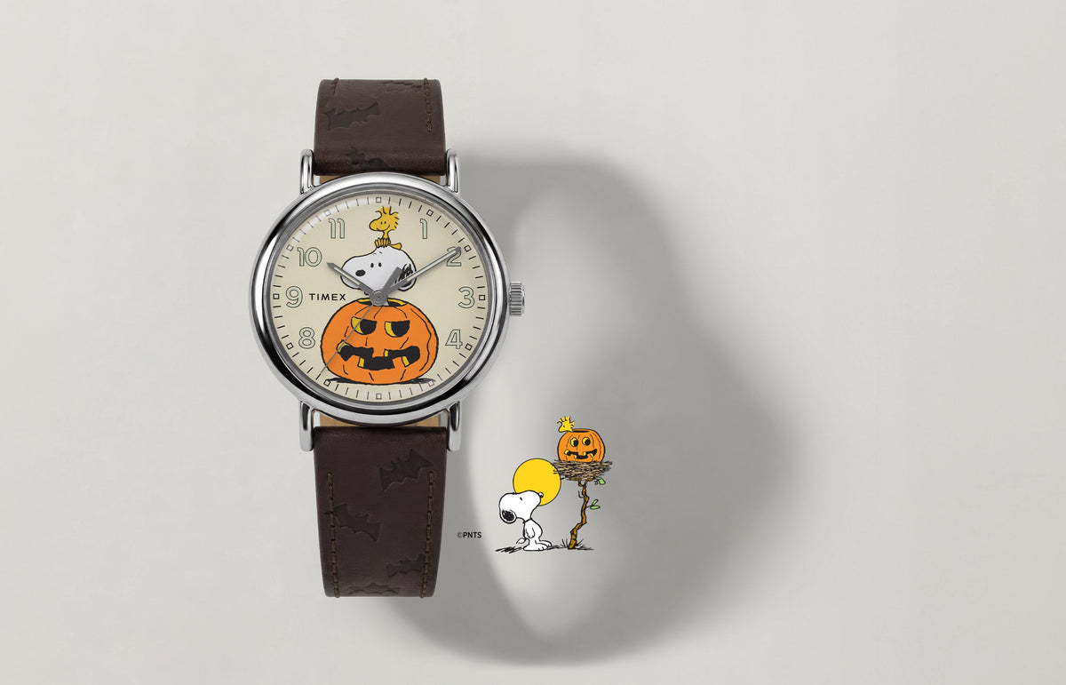 Peanuts® x Timex Weekender® Pumpkin watch with a brown leather strap and a cream dial featuring Snoopy, Woodstock, and a jack-o’-lantern.