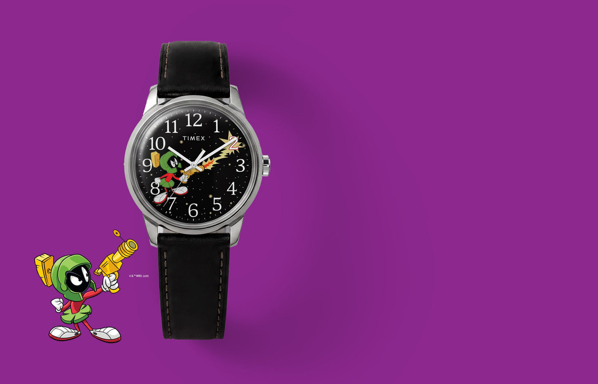 TW2Y99300 Looney Tunes Marvin the Martian x Timex Easy Reader® watch with a black character dial and black leather strap beside Marvin artwork on purple.