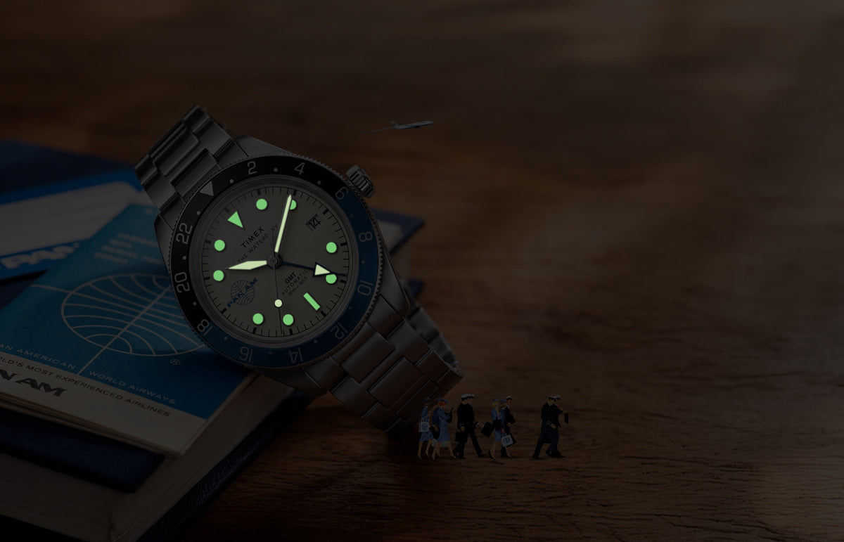 TW2Y94300 Pan Am x Timex Waterbury Automatic GMT watch with luminous hands and markers glowing in the dark.