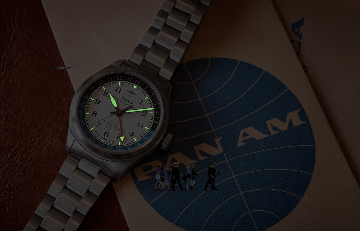 TW2Y94600 Pan Am x Timex Waterbury Automatic GMT watch with luminous hands and hour markers glowing in the dark.