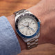 TW2Y94300 Close-up of the Pan Am x Timex Waterbury Automatic GMT watch worn with a light blue shirt.