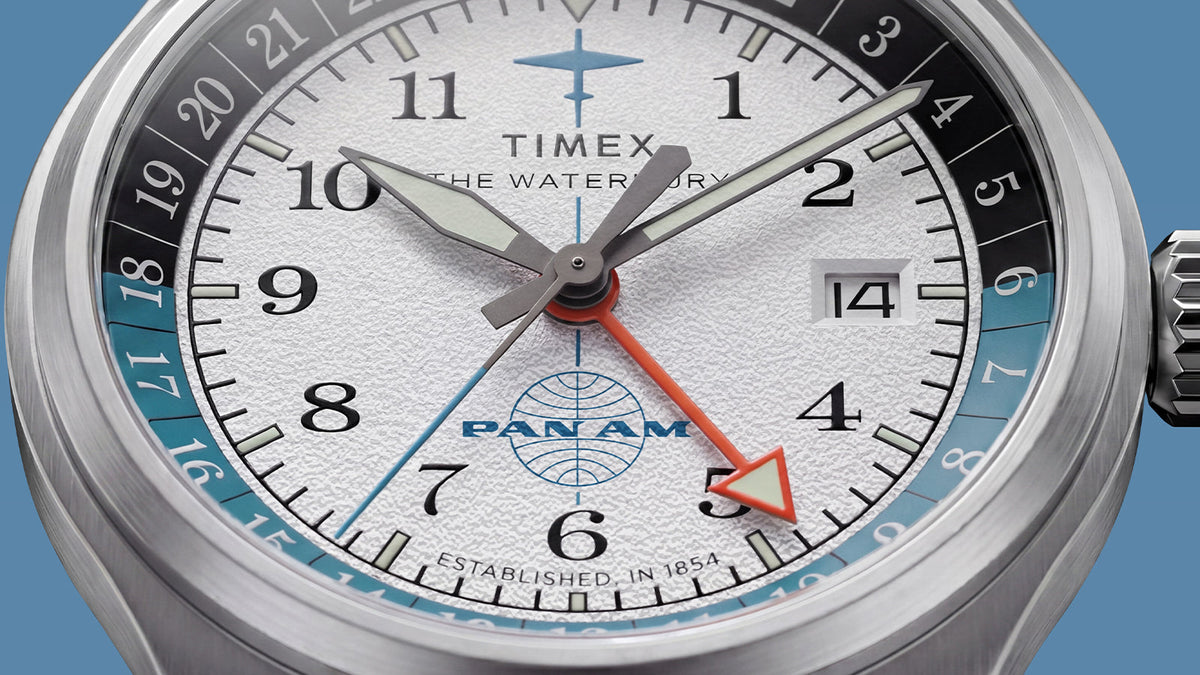TW2Y94600 Close-up of the textured white dial, orange GMT hand, date window, and two-tone 24-hour scale.