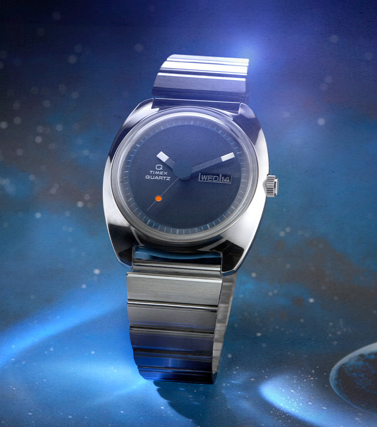 The image shows Q Timex 1975 Enigma Reissue Watch in a galaxy-like night sky.