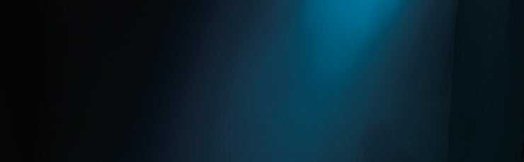 A diver in a wetsuit floats underwater against a dark blue gradient background with soft lighting, evoking a sense of depth and mystery.