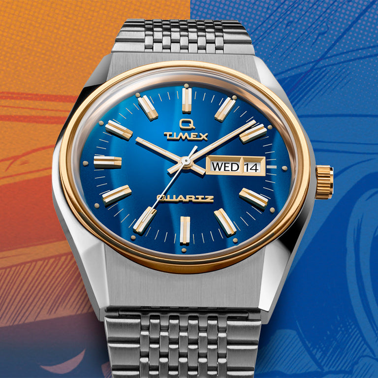 Timex Q Reissue watch with a sunburst blue dial, gold-tone markers and bezel, and a brushed silver-tone case. It features a stainless steel woven bracelet, styled against a vibrant comic-style orange and blue background.