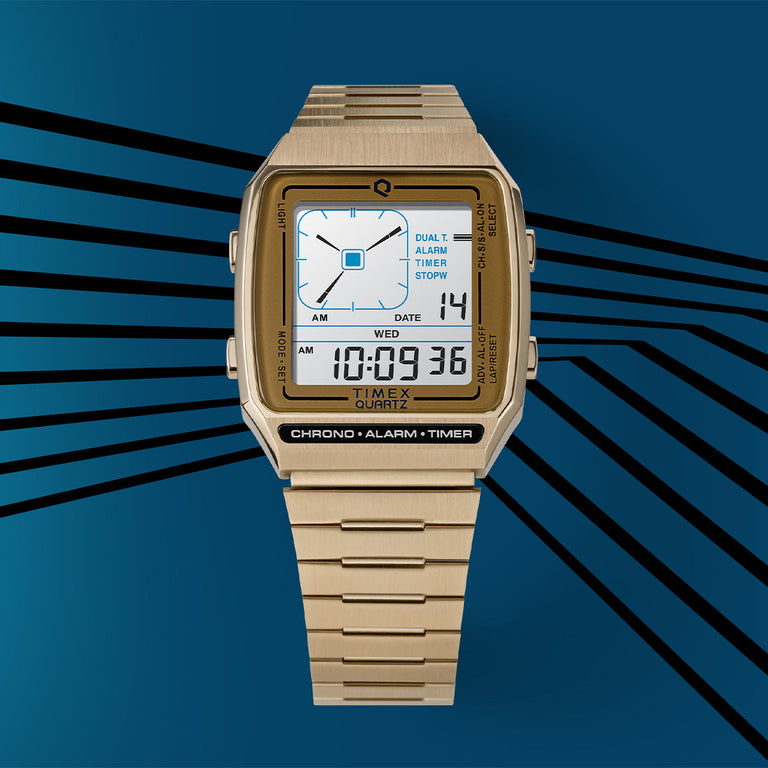 Gold-tone digital Timex Q Reissue watch with a square case and multifunction display. Set against a blue graphic background with radiating black stripes, evoking a retro-futuristic theme.
