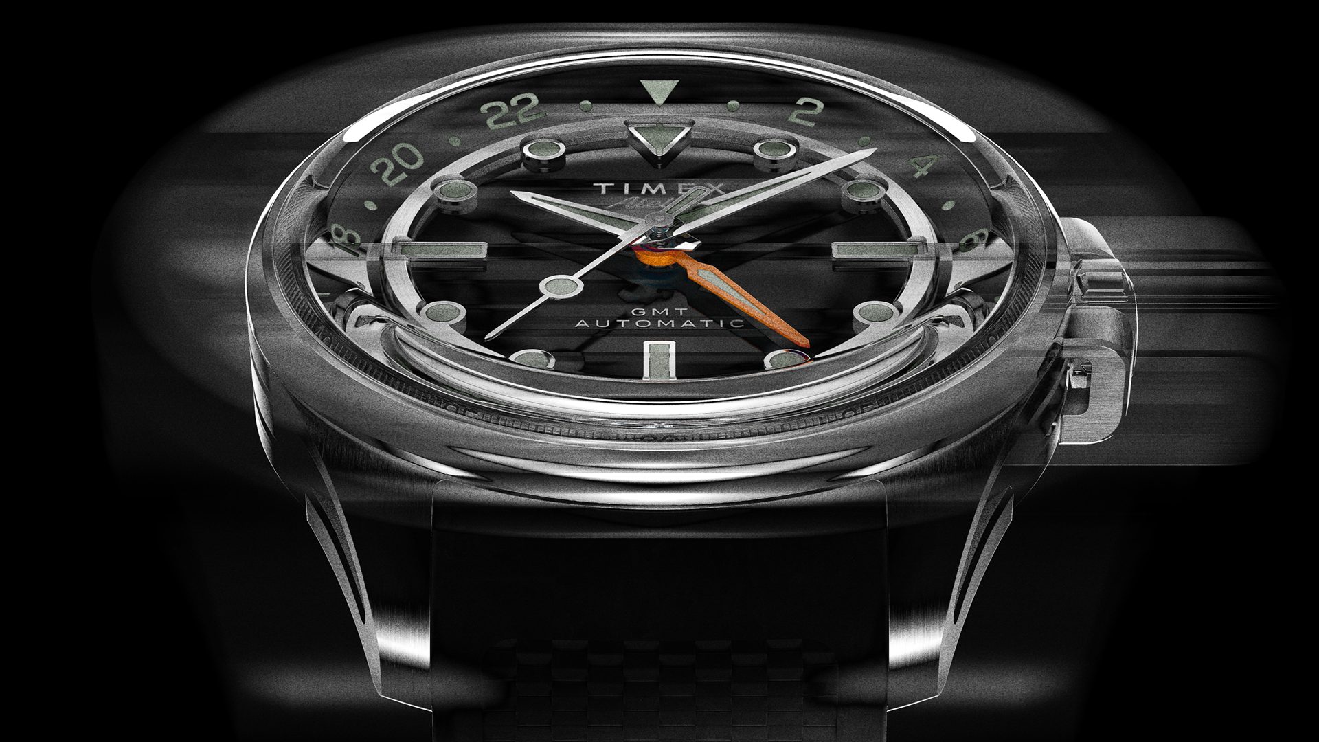 Front motion-blur image of the Timex Atelier GMT Automatic highlighting its polished stainless steel case and dynamic dial design.