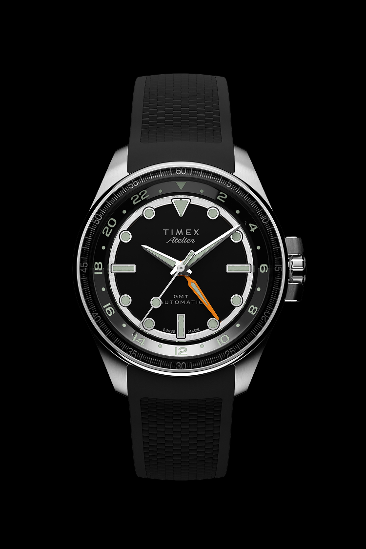 Front view of the Timex Atelier GMT Automatic with a black dial, orange GMT hand, and black rubber strap.