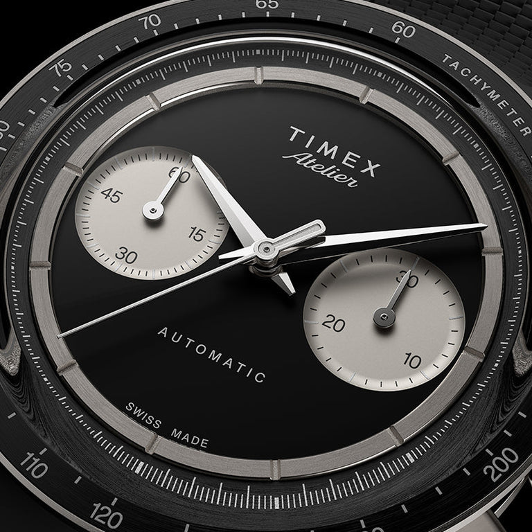Close-up of the Timex Atelier Chronograph Automatic M1a Ti black dial featuring contrasting silver-tone sub-dials, applied markers, and polished chronograph hands.
